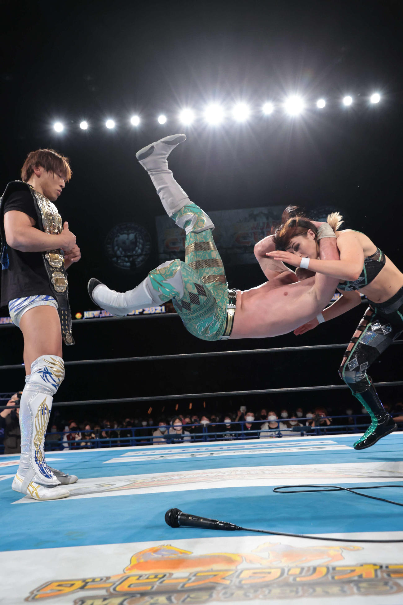 新日本プロレス宮城大会　恋人のビー・プレストリー（右）にオスカッターを浴びせるウィル・オスプレイ。左は飯伏幸太（新日本プロレス提供）