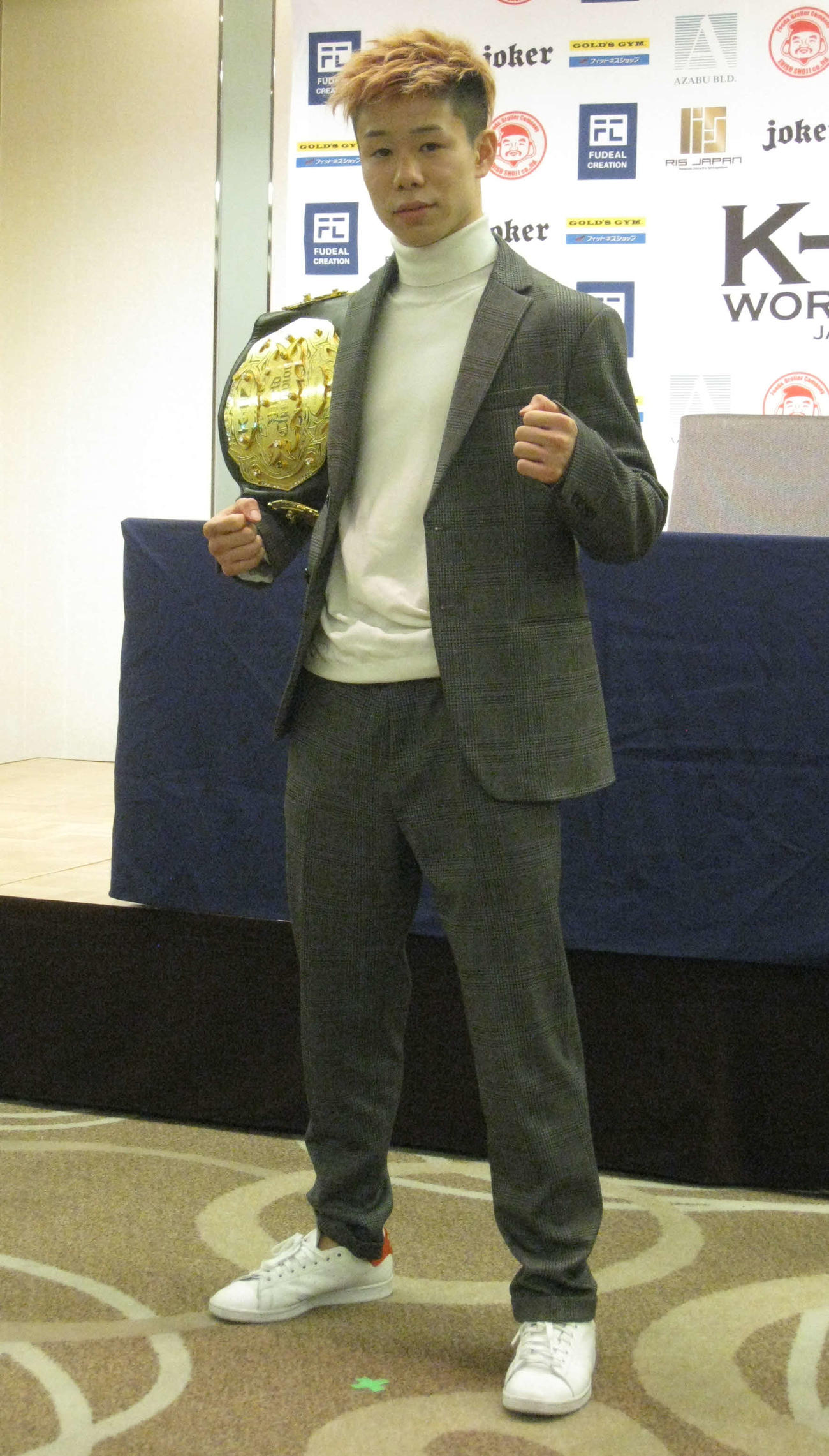 ベルトを肩に会見場に現れた椿原龍矢（撮影・吉池彰）