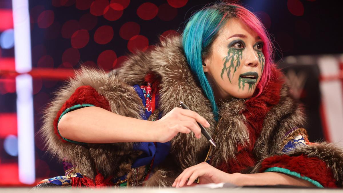 挑戦者リプリーをにらみつけながら、調印書にサインするロウ女子王者アスカ（C）2021 WWE, Inc. All Rights Reserved.