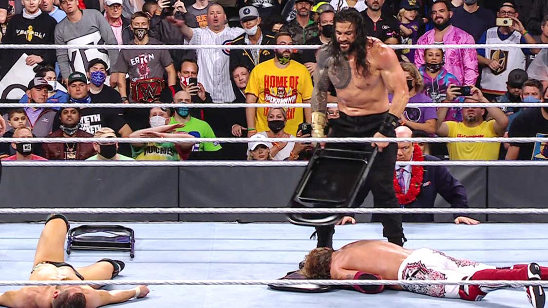 ブライアン（手前左）、エッジ（手前右）にパイプいす攻撃を加えるWWEユニバーサル王者レインズ（C）2021 WWE, Inc. All Rights Reserved.