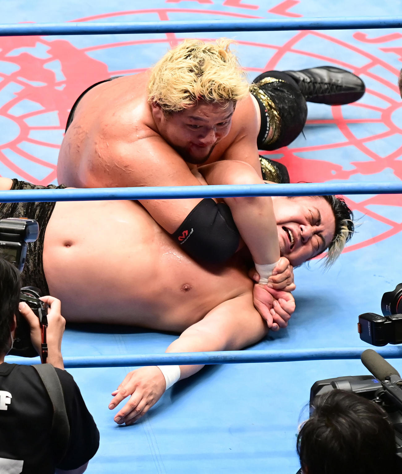 石川（上）に試合途中で痛めた首を攻められる諏訪魔（撮影・小沢裕）