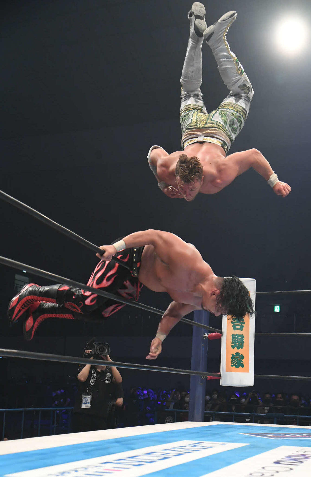 新日本プロレス福岡大会　鷹木信悟をロープに乗せ、コーナートップからシューティングスタープレスを決めるウィル・オスプレイ（新日本プロレス提供）