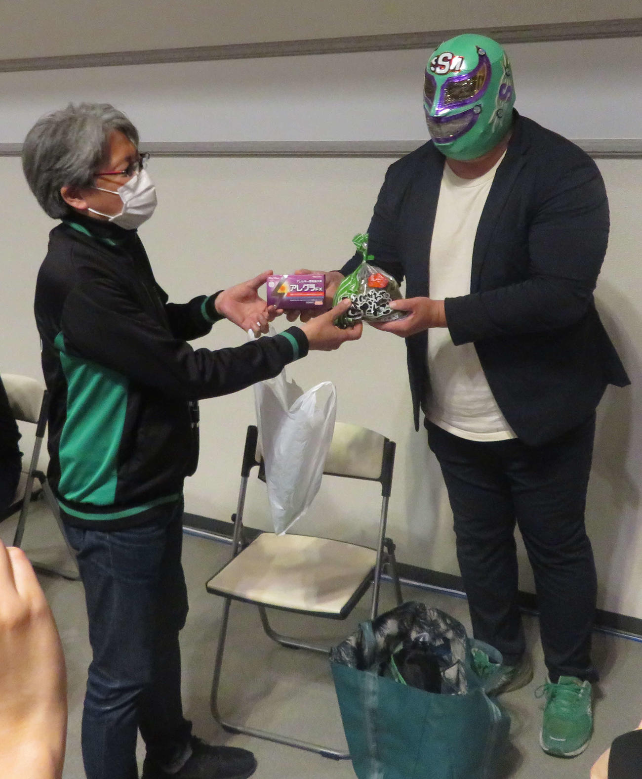 プロレスリング・ノア横浜大会　スタッフに笹団子とアレルギーの薬を手渡すスーパー・ササダンゴ・マシン（右）（撮影・松熊洋介）
