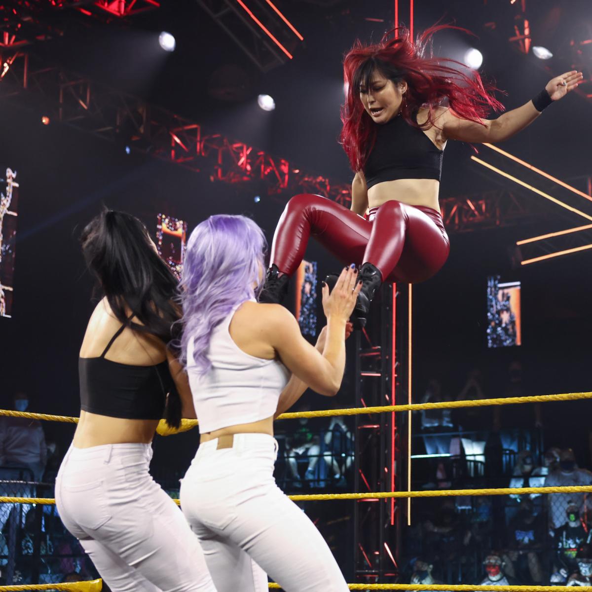NXT女子タッグ王者レラエ（手前右）、ハートウェル（同左）にミサイルキックを放った紫雷（C）2021 WWE, Inc. All Rights Reserved.