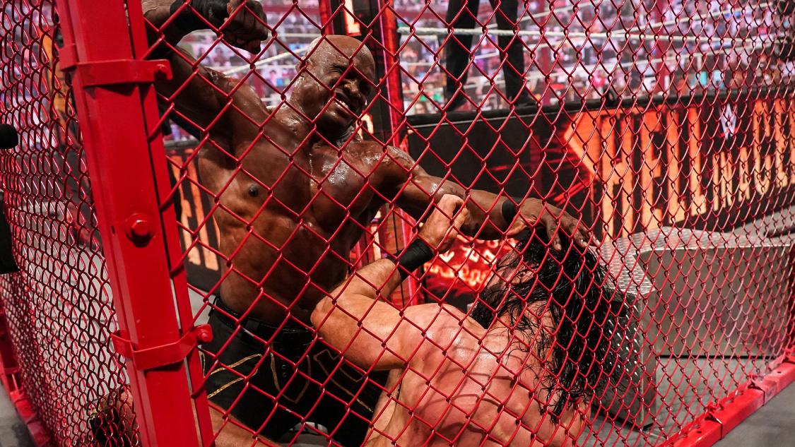 場外のケージで挑戦者マッキンタイア（右）を殴るWWEヘビー級王者ラシュリー（C）2021 WWE, Inc. All Rights Reserved.