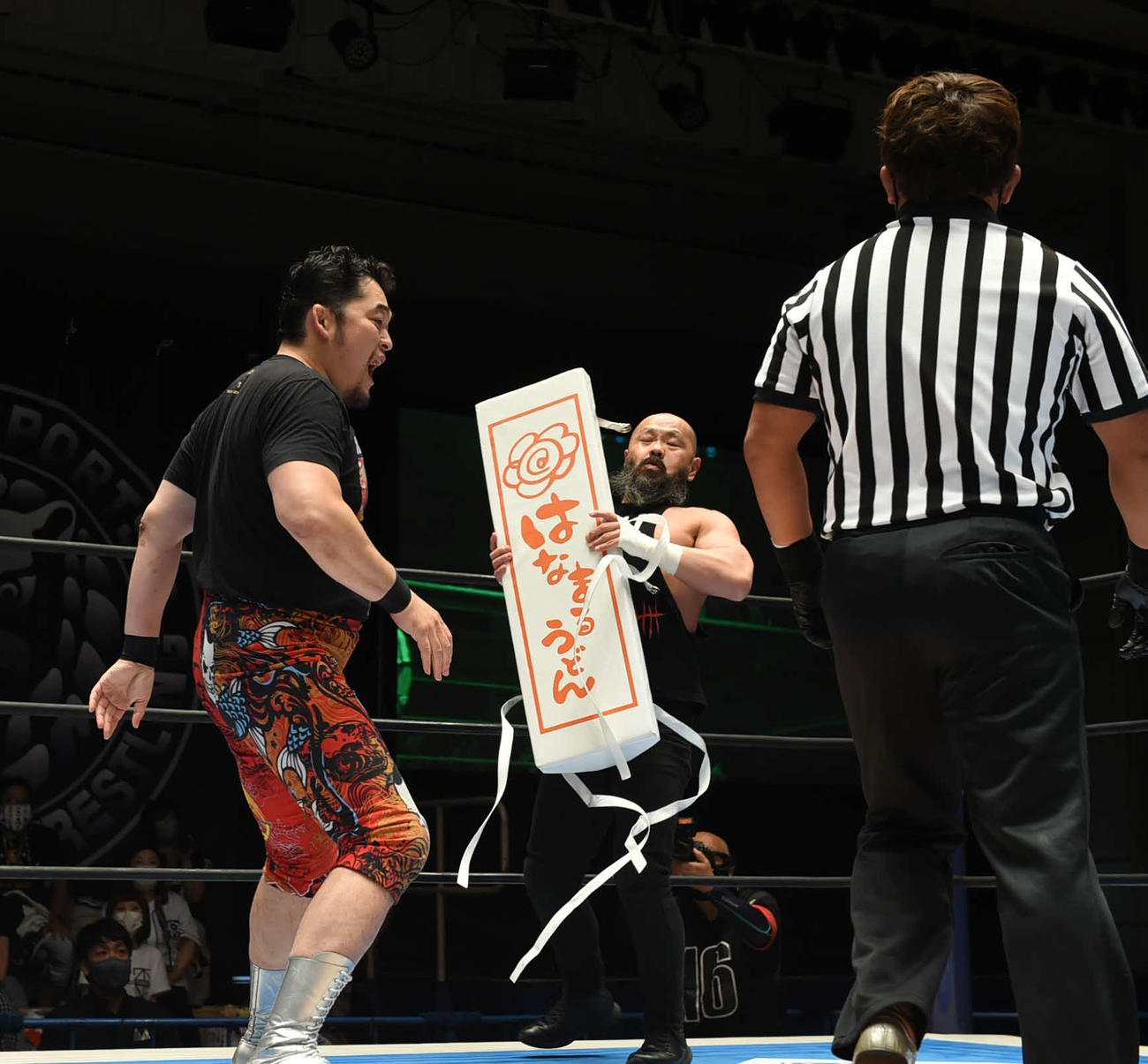 新日本プロレス後楽園大会　外道（中央）にコーナーパッドを渡し、攻撃を仕掛ける矢野通（左）（新日本プロレス提供）