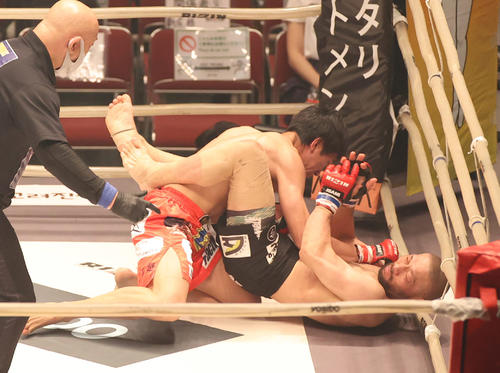 滝沢謙太対今成正和　1回、今成（右）をリングサイドで追いつめる滝沢（撮影・清水貴仁）