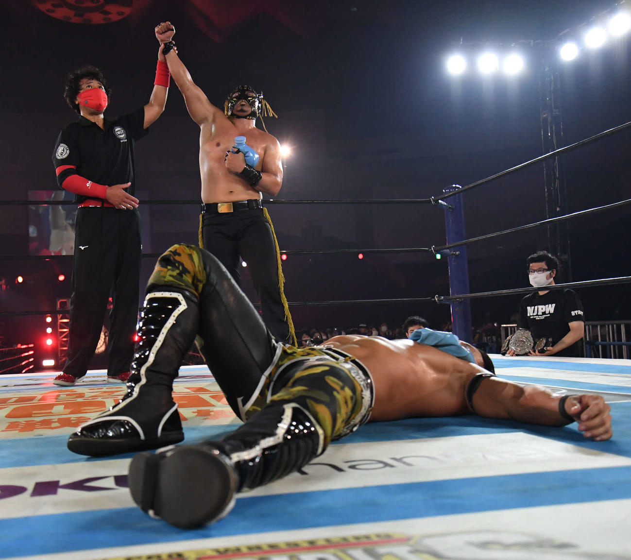 IWGPジュニアヘビー級王座2度目の防衛に成功し、勝ち名乗りを受けるエル・デスペラード（中央）。手前は敗れた石森太二（新日本プロレス提供）