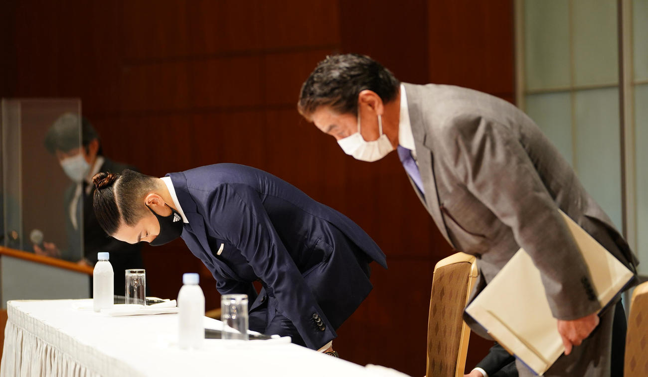 登壇し、一礼しながら着席する井岡（左）と永田理事長（撮影・菅敏）