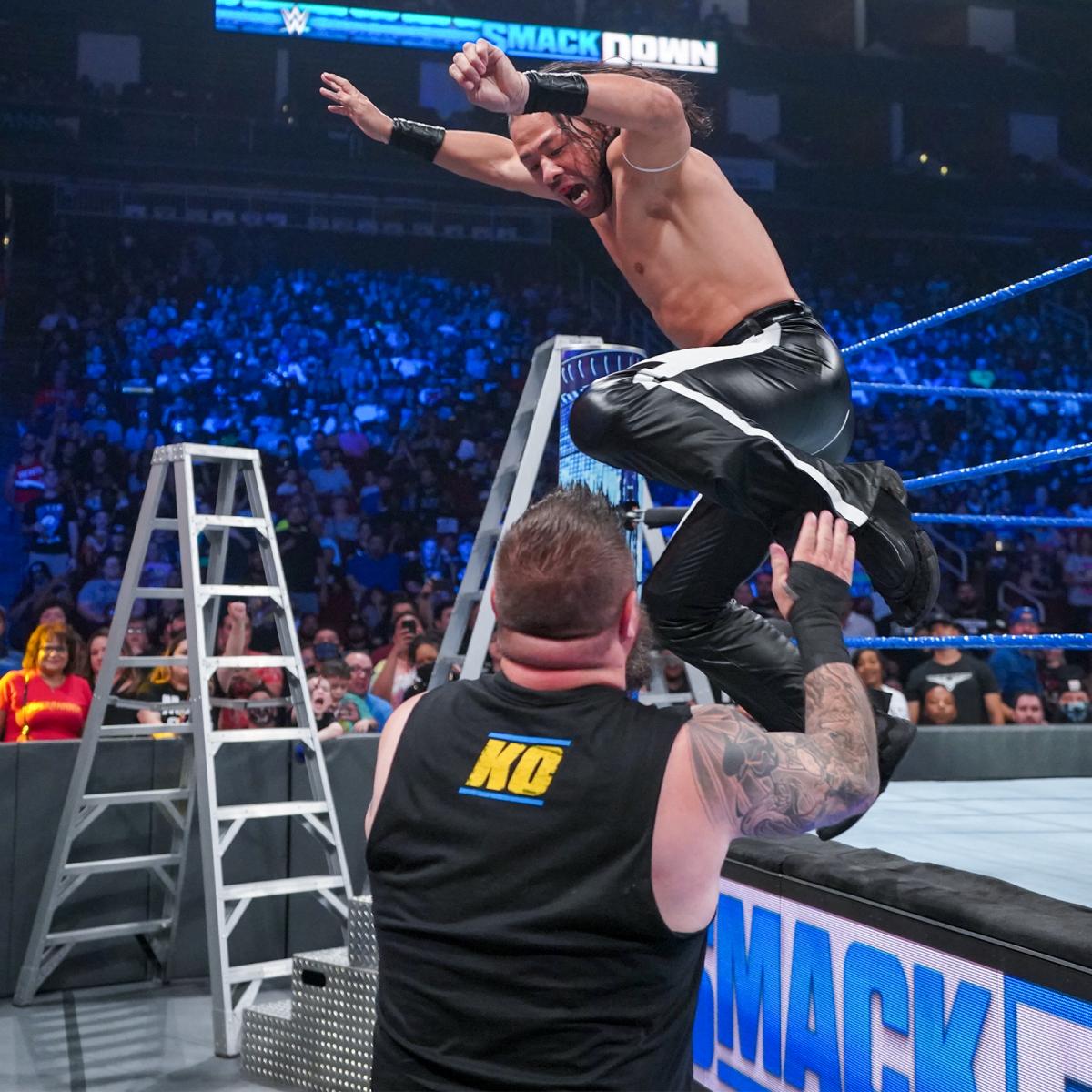 オーエンズ（手前）にエプロンからの飛び膝蹴りを仕掛けた中邑（C）2021 WWE, Inc. All Rights Reserved.