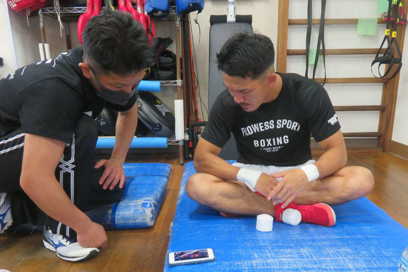 IBF世界スーパーフェザー級王座決定戦に備え、田中トレーナー（左）とともに同級1位ラヒモフの映像をチェックする同級3位尾川