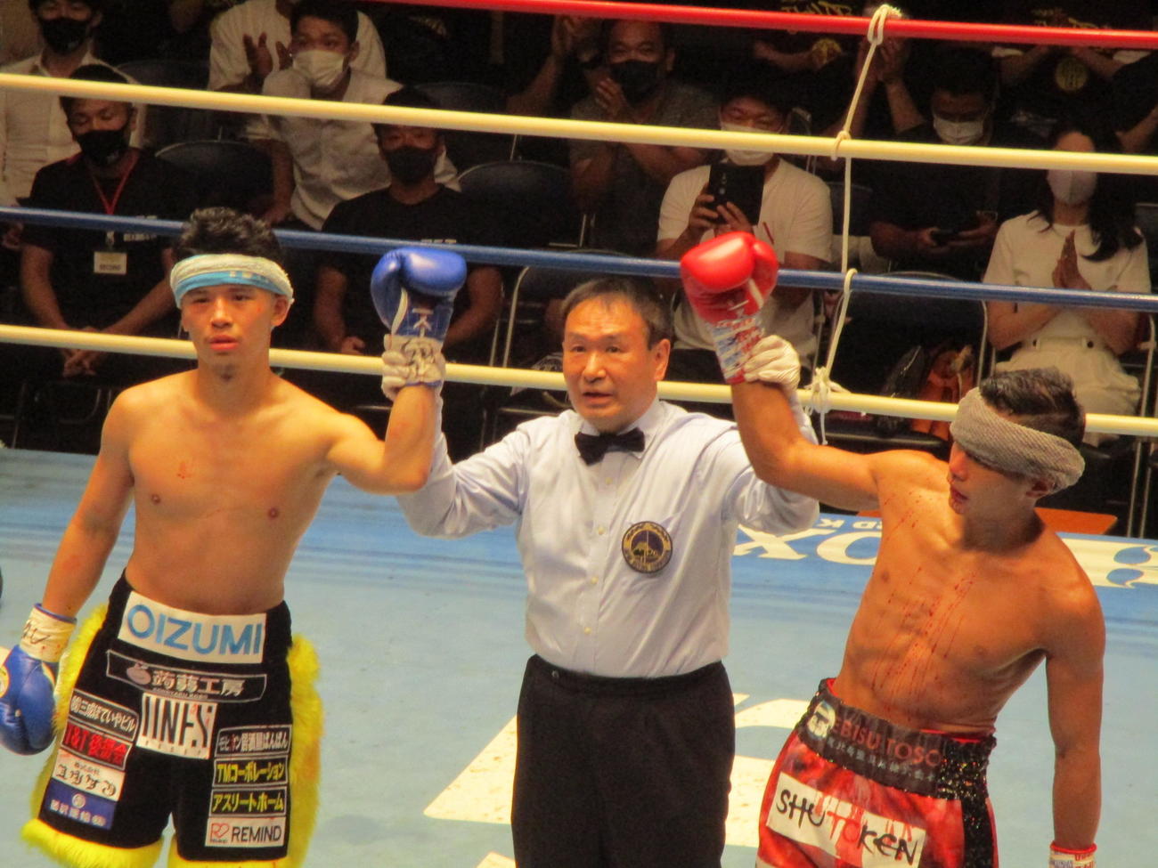 負傷引き分けで眉間の傷にタオルを巻いた定常育郎（左）と沢田京介（右）