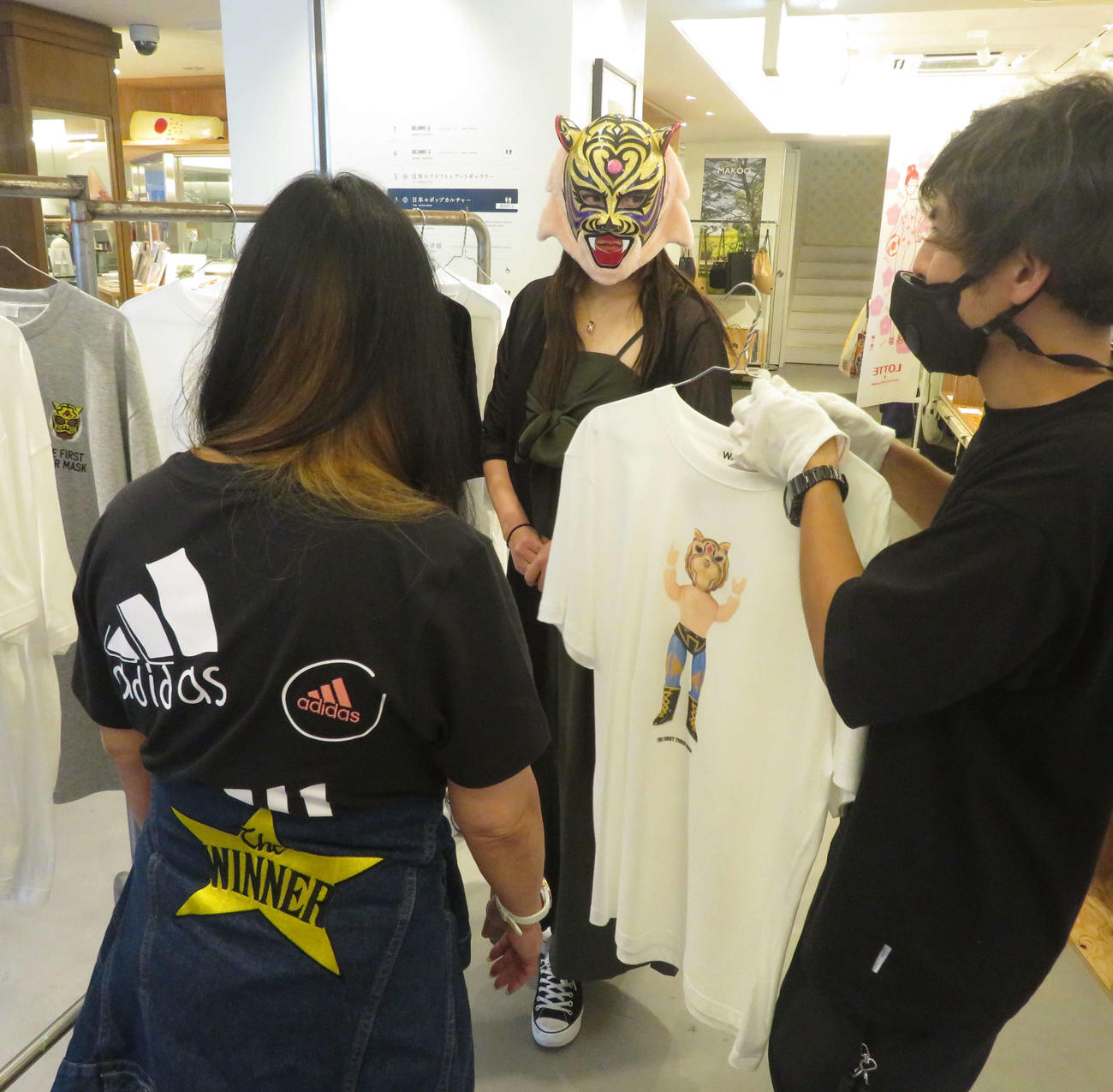 スタッフから記念Tシャツについての説明を聞くタイガー・クイーン（中央）。左はジャガー横田（撮影・松熊洋介）