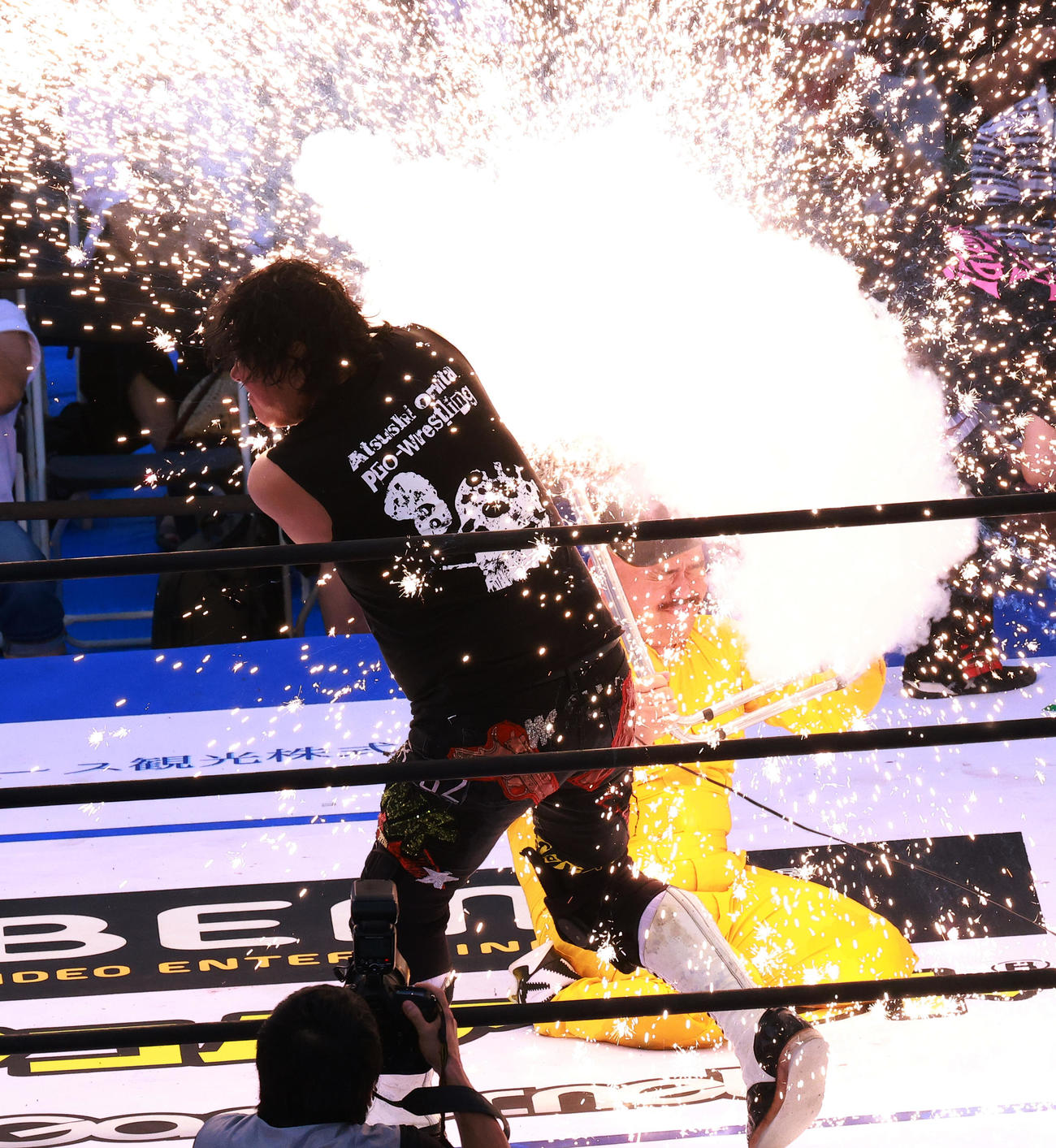 座り込んだクロちゃん（右）に電流バットを浴びせる大仁田（撮影・中島郁夫）