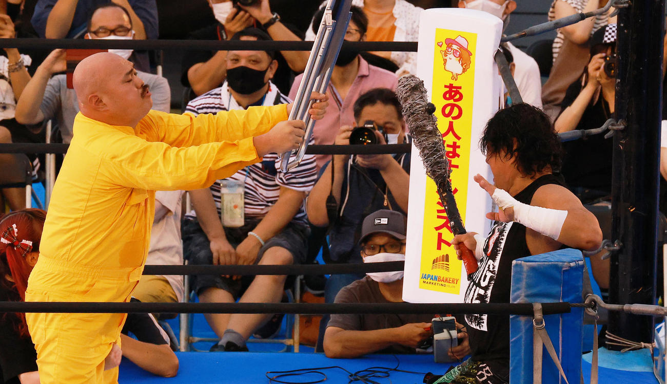 大仁田（右）にパイプイス攻撃を仕掛けるクロちゃん（撮影・中島郁夫）