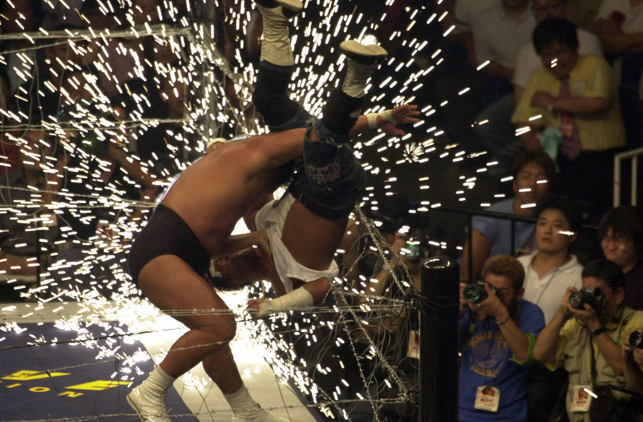 長州力は大仁田厚を有刺鉄線に投げつける（2000年7月30日撮影）