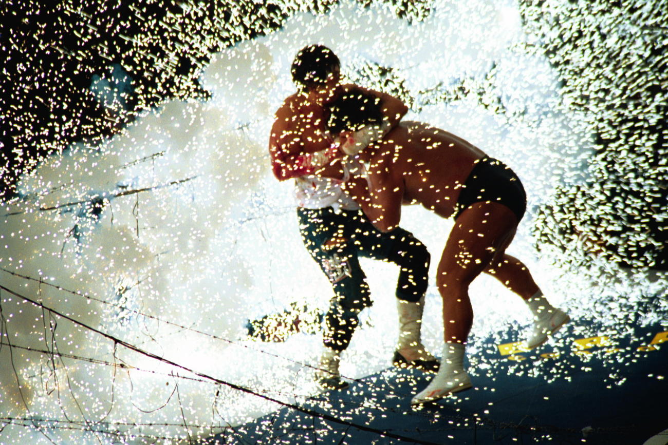 長洲力（左）は大仁田厚をロープに追いつめ爆破。リング上にせん光が走る