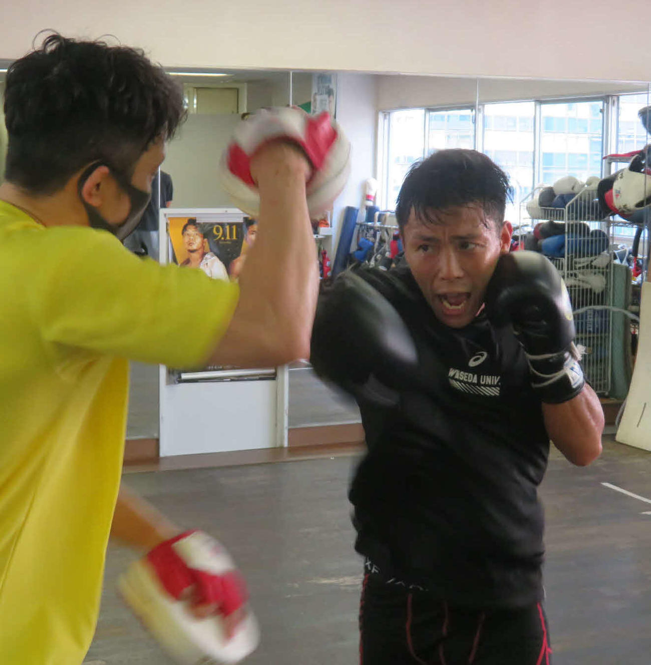 粟生トレーナー（左）の持つミットに強烈な右を放つ岩田