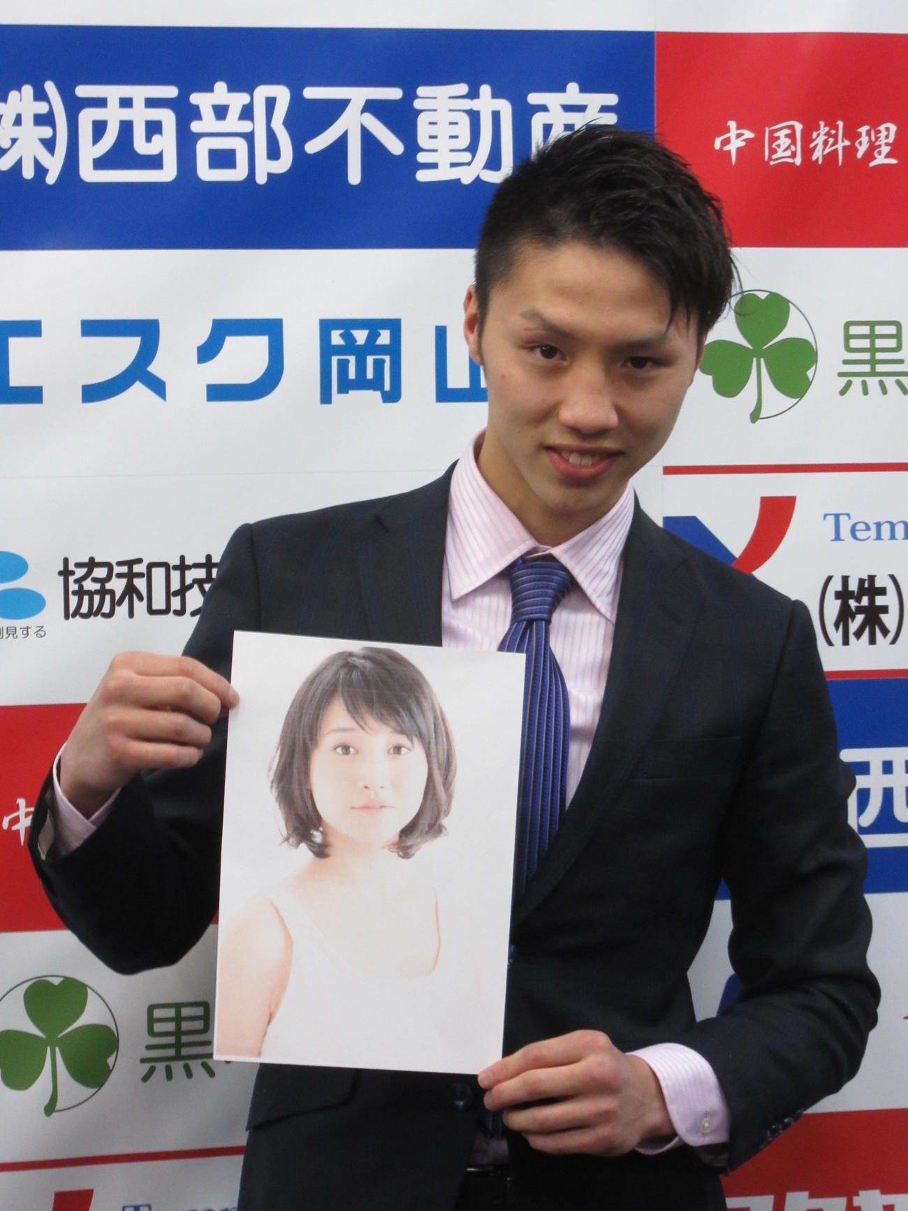 ラウンドガールを務める若手女優森岡朋奈の写真を持つ丸田陽七太（2016年2月22日撮影）