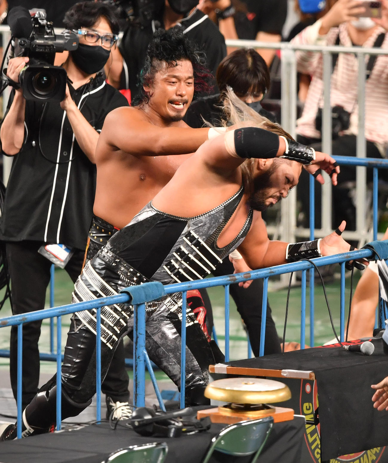 IWGP世界ヘビー級選手権　鷹木信悟（左）はEVILを鉄柵にたたきつける（撮影・柴田隆二）