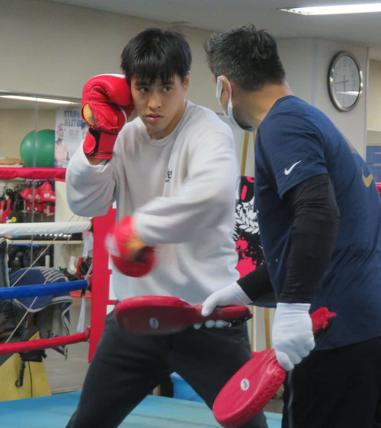 小山トレーナー（右）の指導を受けながらミット打ちに取り組む赤井