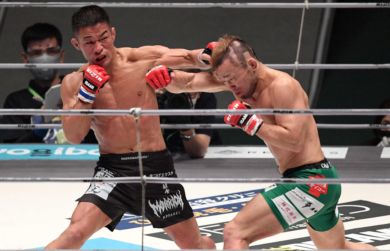 3回、パンチを交錯させる大塚（左）と扇久保（撮影・滝沢徹郎）