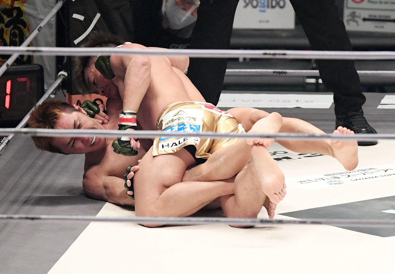 1回、久保（下）にパンチを見舞う太田（撮影・滝沢徹郎）
