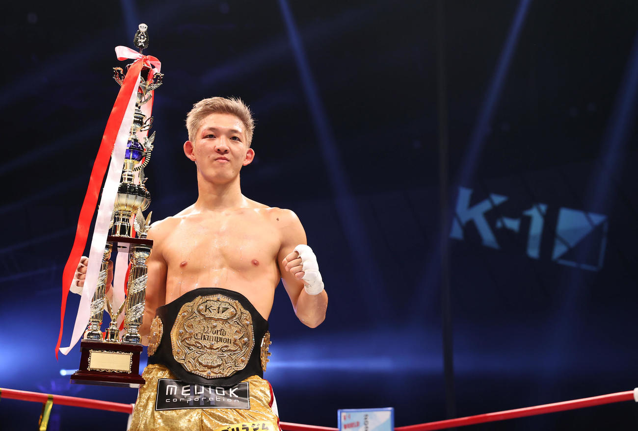 第2代ウエルター級王座決定トーナメントで優勝しチャンピオンベルトを巻きトロフィーを手に写真に納まる野杁（撮影・垰建太）