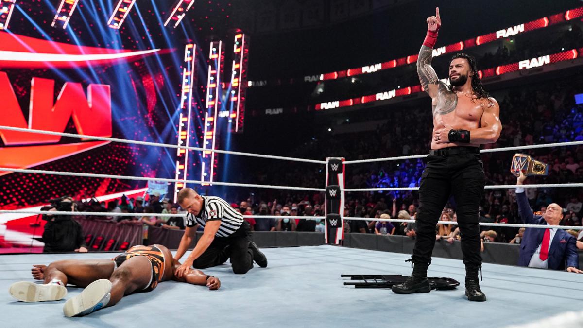 倒れたWWEヘビー級王者ビックE（左端）を横目に勝ち誇るWWEユニバーサル王者レインズ（右端）（C）2021 WWE, Inc. All Rights Reserved.