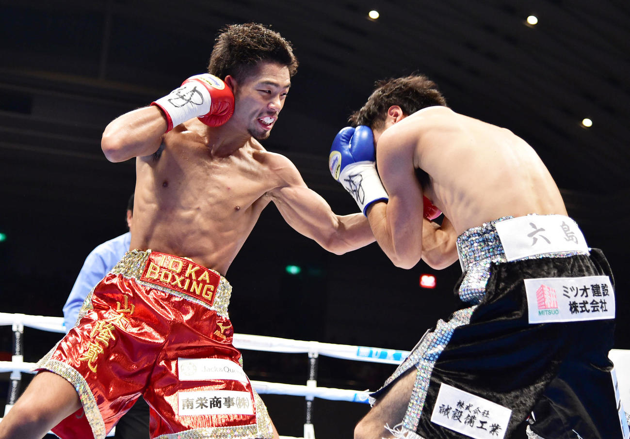 東洋太平洋バンタム級タイトルマッチ12回戦　山本隆寛対ストロング小林佑樹　1回、小林（右）にパンチを見舞う山本（2015年12月31日撮影）