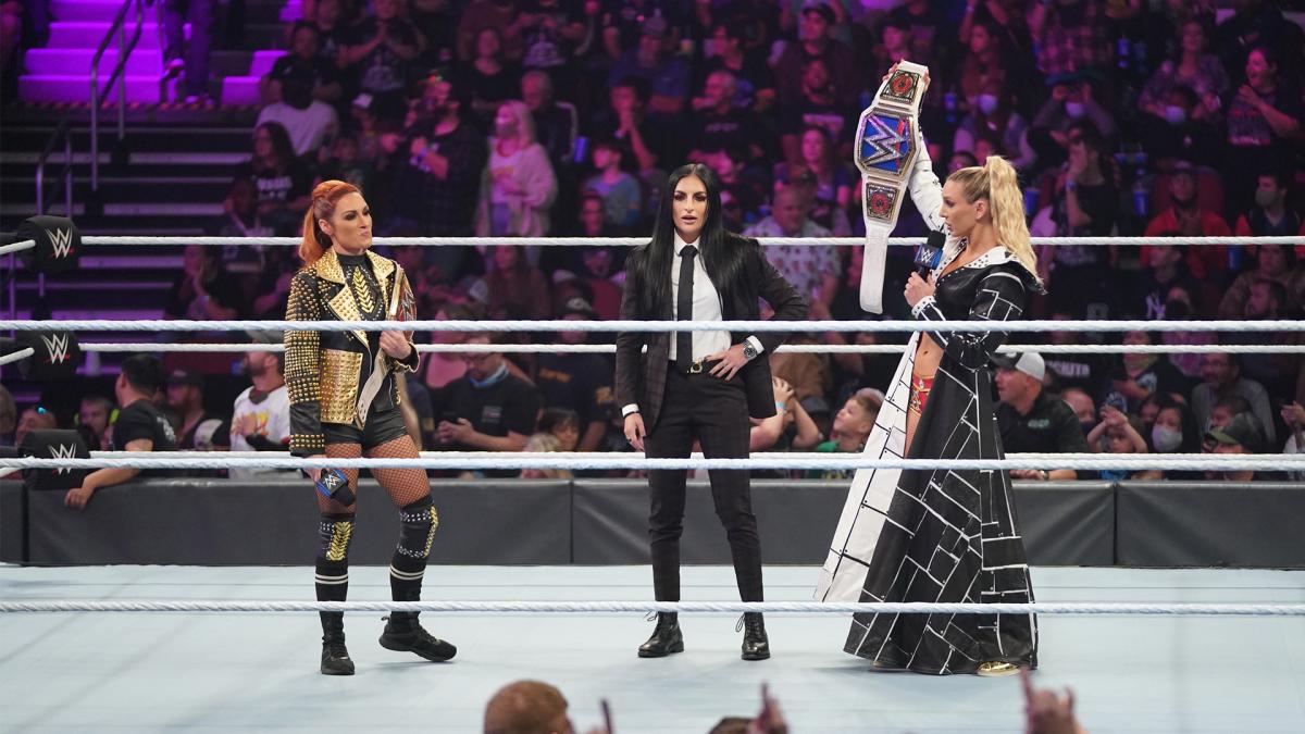 リンチ（左端）と王座の交換を終え、SD女子王座ベルトを掲げたフレアー（右端）。中央はWWEオフィシャルのデビル（C）2021 WWE, Inc. All Rights Reserved.