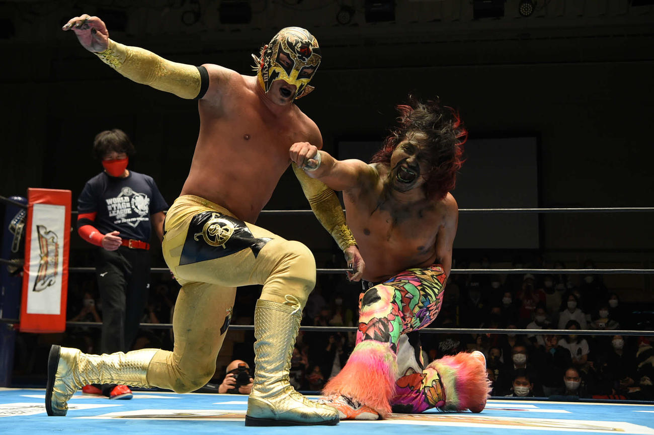 顔を緑に染めながらもBUSHI（左）にこん身の一撃を繰り出す高橋（提供：新日本プロレス）