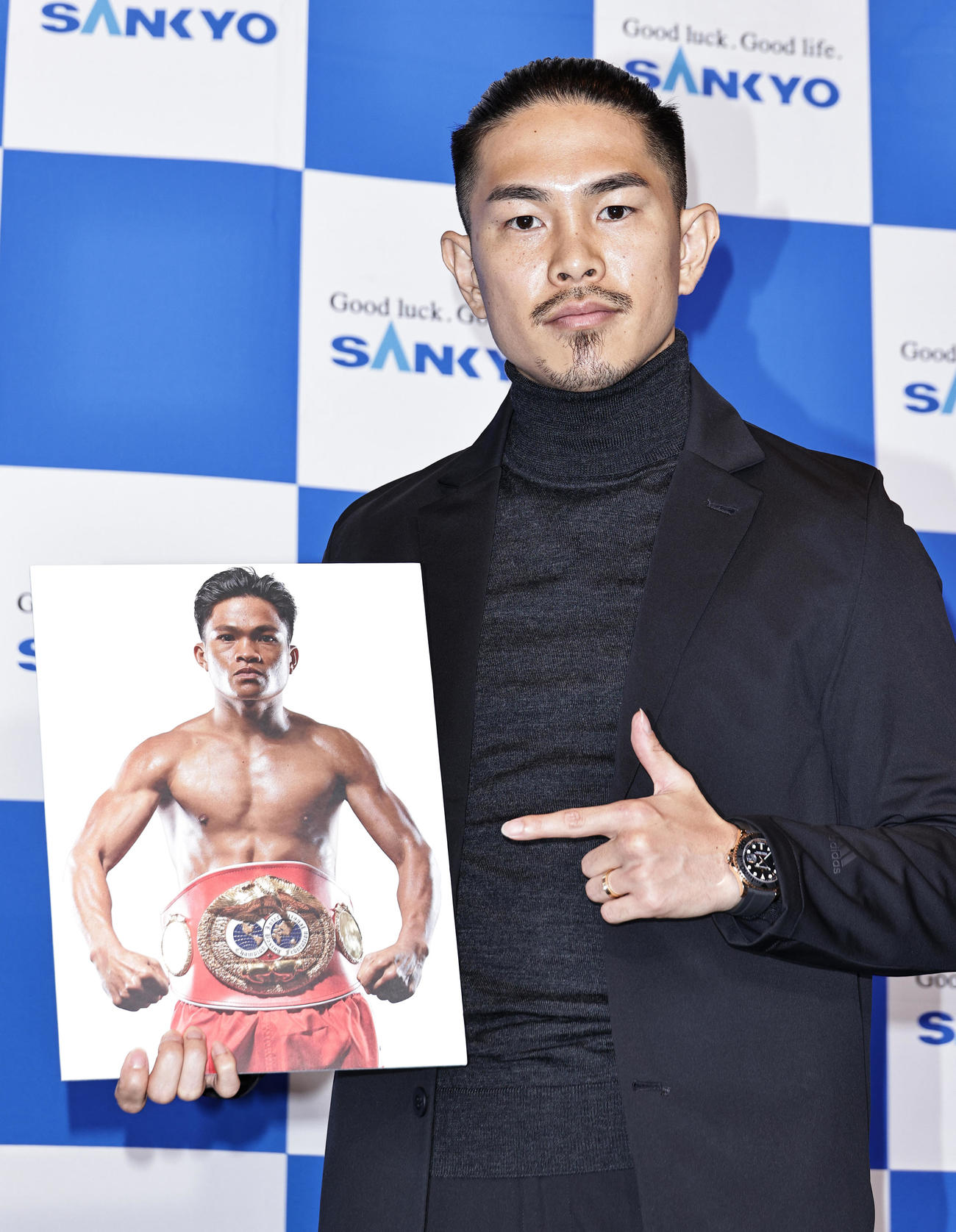 WBO・IBF世界スーパーフライ級王座統一戦の会見でアンカハス選手の写真パネルを手にするWBO世界スーパーフライ級王者井岡（撮影・中島郁夫）