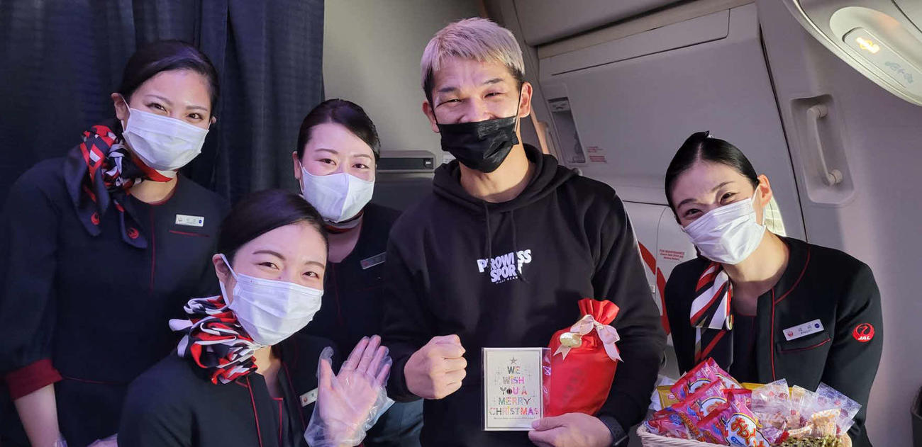 帰国便内でCAからIBF世界スーパーフェザー級王座奪取を祝福された新王者尾川（左から4人目＝尾川本人提供）