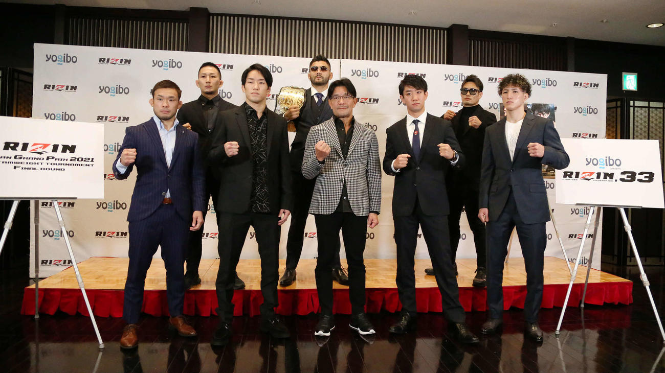 RIZIN33大会の対戦カード発表記者会見で写真に納まる、前列左から扇久保博正、朝倉海、榊原信行CEO、瀧沢謙太、井上直樹、後列左から元谷友貴、ホベルト・サトシ・ソウザ、金太郎（撮影・丹羽敏通）