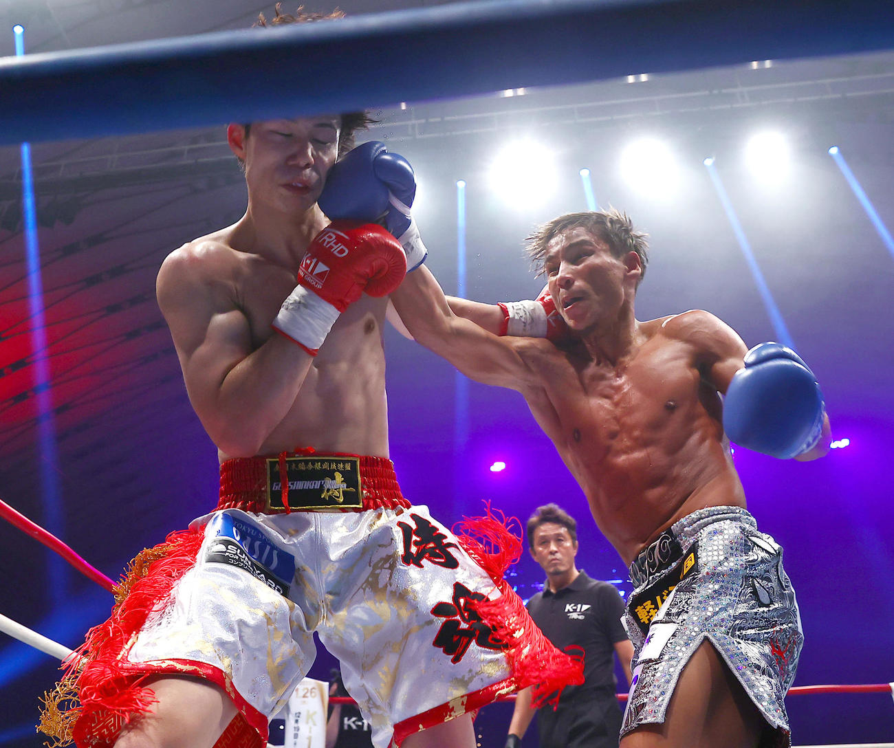 第16試合・K－1 WORLD GP　フェザー級タイトルマッチ　椿原龍矢対軍司泰斗　延長戦で椿原（左）にパンチを浴びせる軍司（撮影・上山淳一）