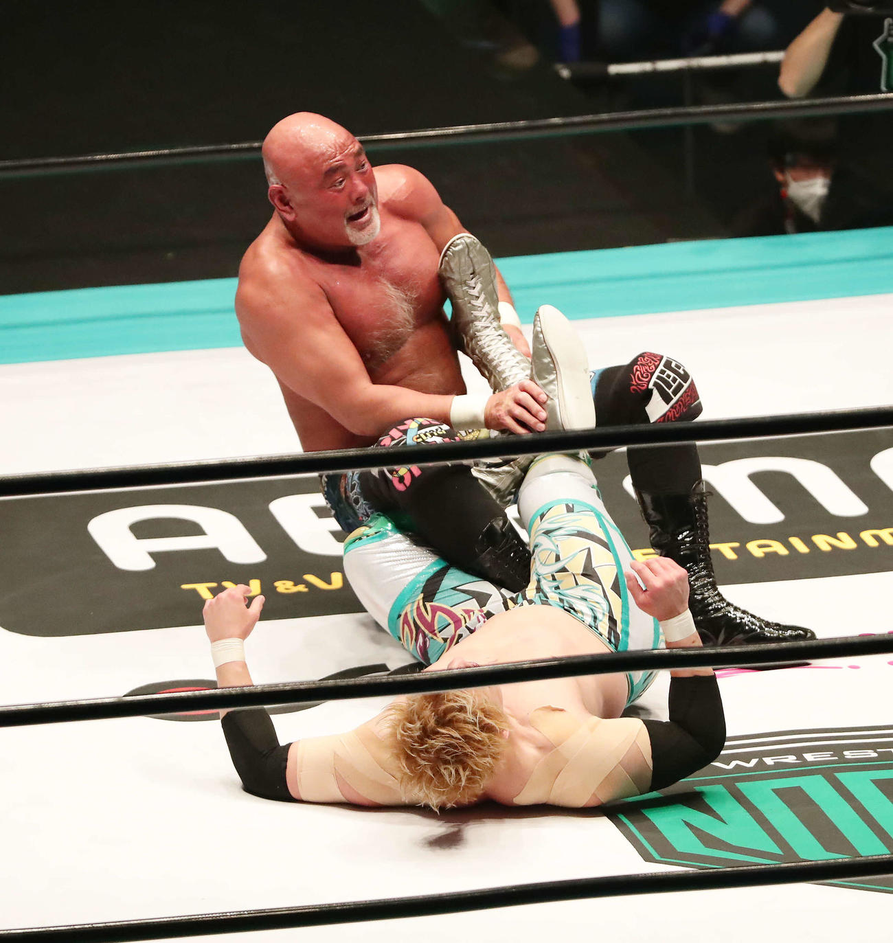 GHCヘビー級選手権　チャンピオン潮崎豪（手前）を足4の字固めで攻める挑戦者武藤敬司（撮影・丹羽敏通）