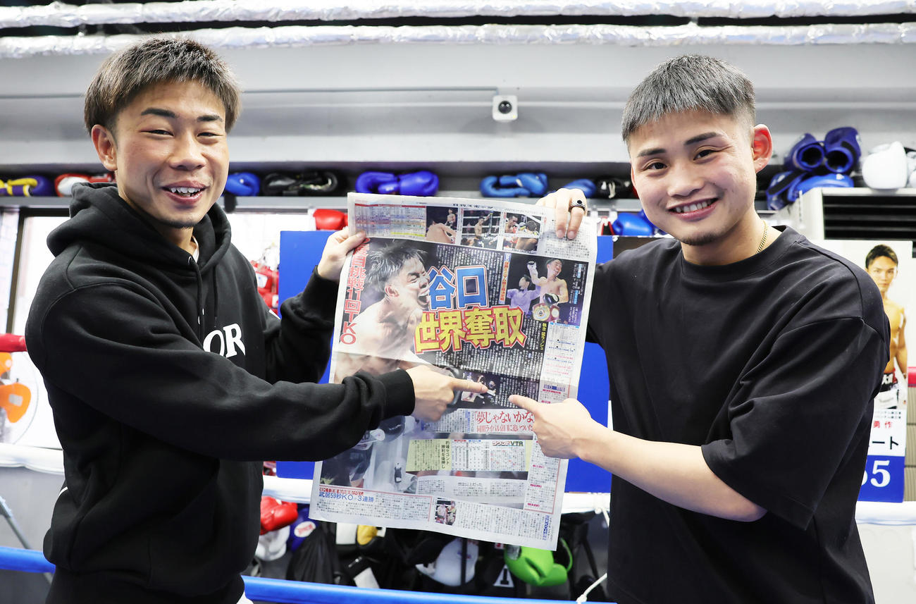 WBOミニマム級新王者となった谷口（左）はセコンドを務めた京口と本紙を指さし笑顔（撮影・足立雅史）