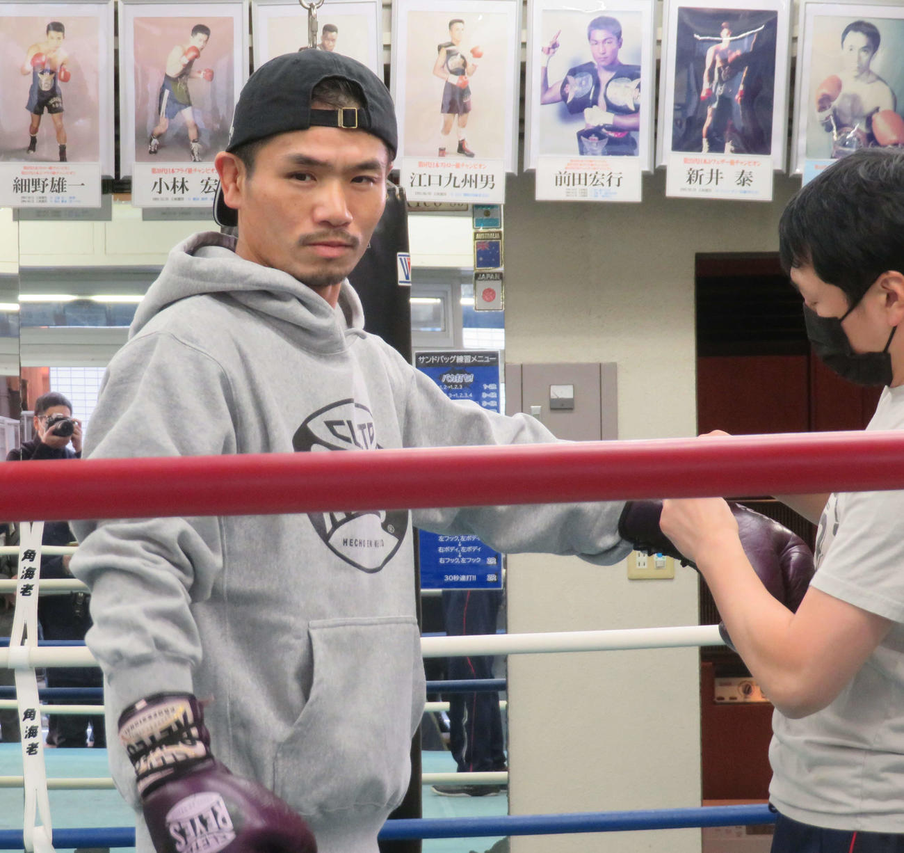 公開練習でミット打ちを披露するためにグローブを巻くWBO世界スーパーフライ級6位福永（左）