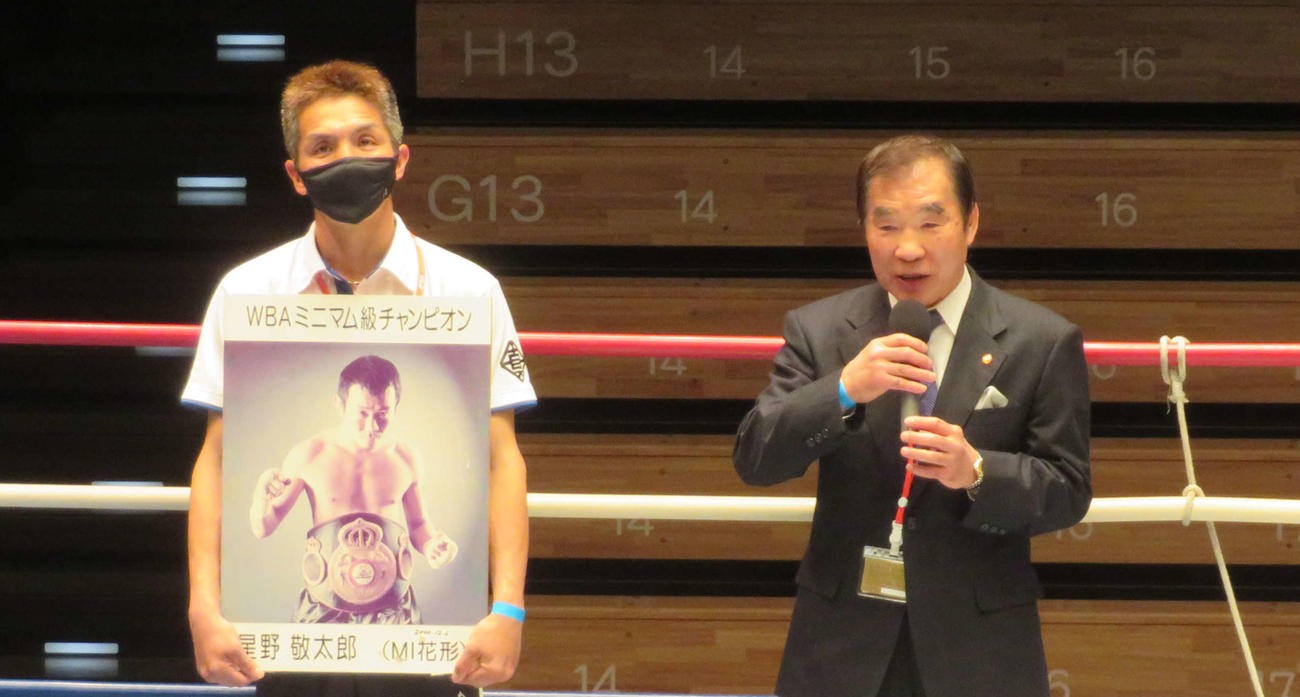 昨年10月に死去した元WBA世界ミニマム級王者星野敬太郎さんの遺影を持つ花形ジム木村トレーナー（左）とあいさつした花形会長