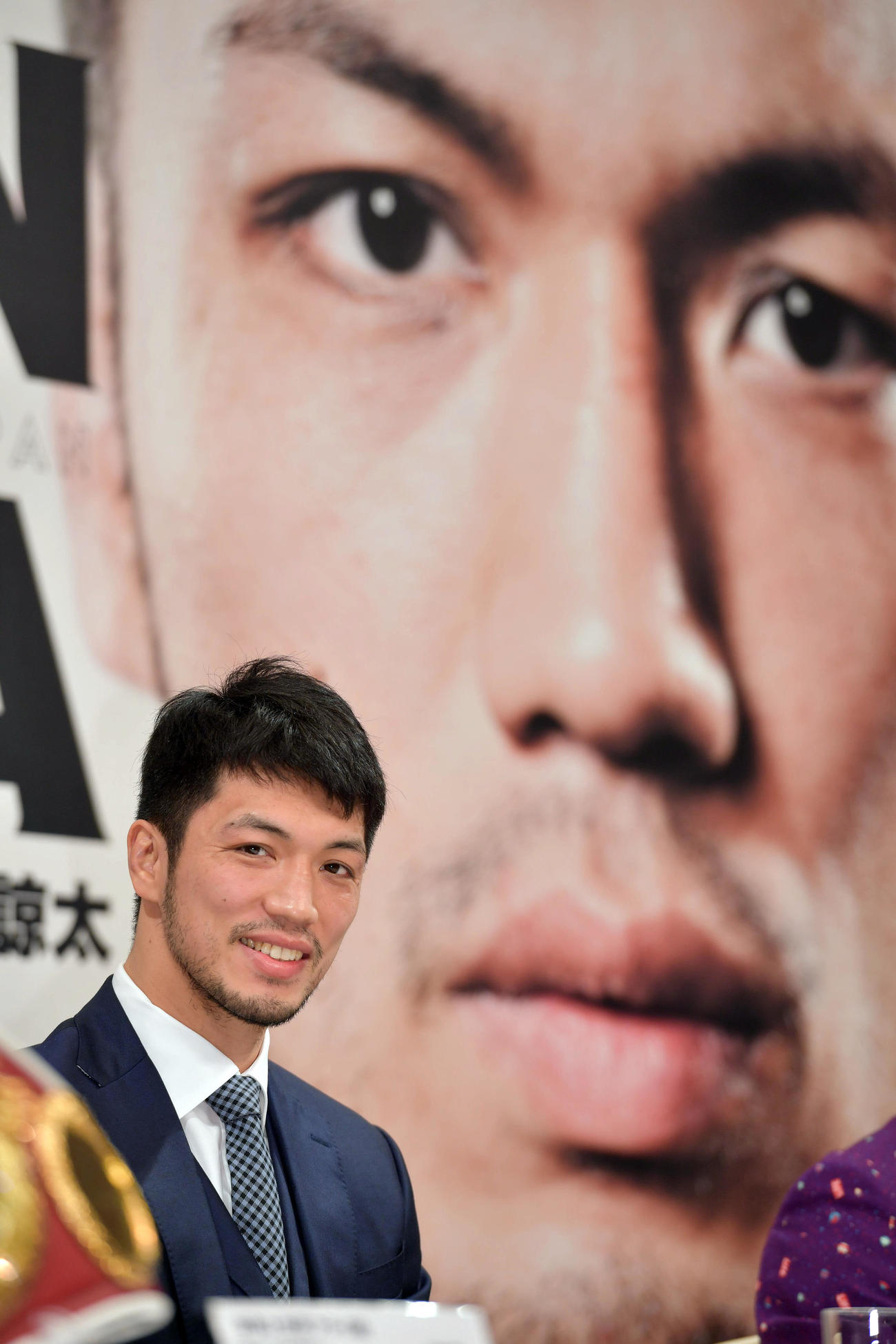 ゴロフキンとの世界ミドル級王座統一戦が決まり自身のパネルの前で笑顔の村田