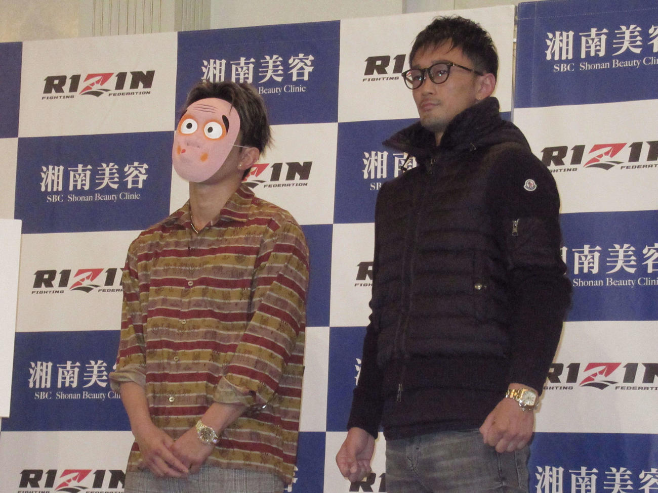 ひょっとこの仮面をつけた皇治（左）は対戦相手の梅野と写真に納まる（撮影・勝部晃多）