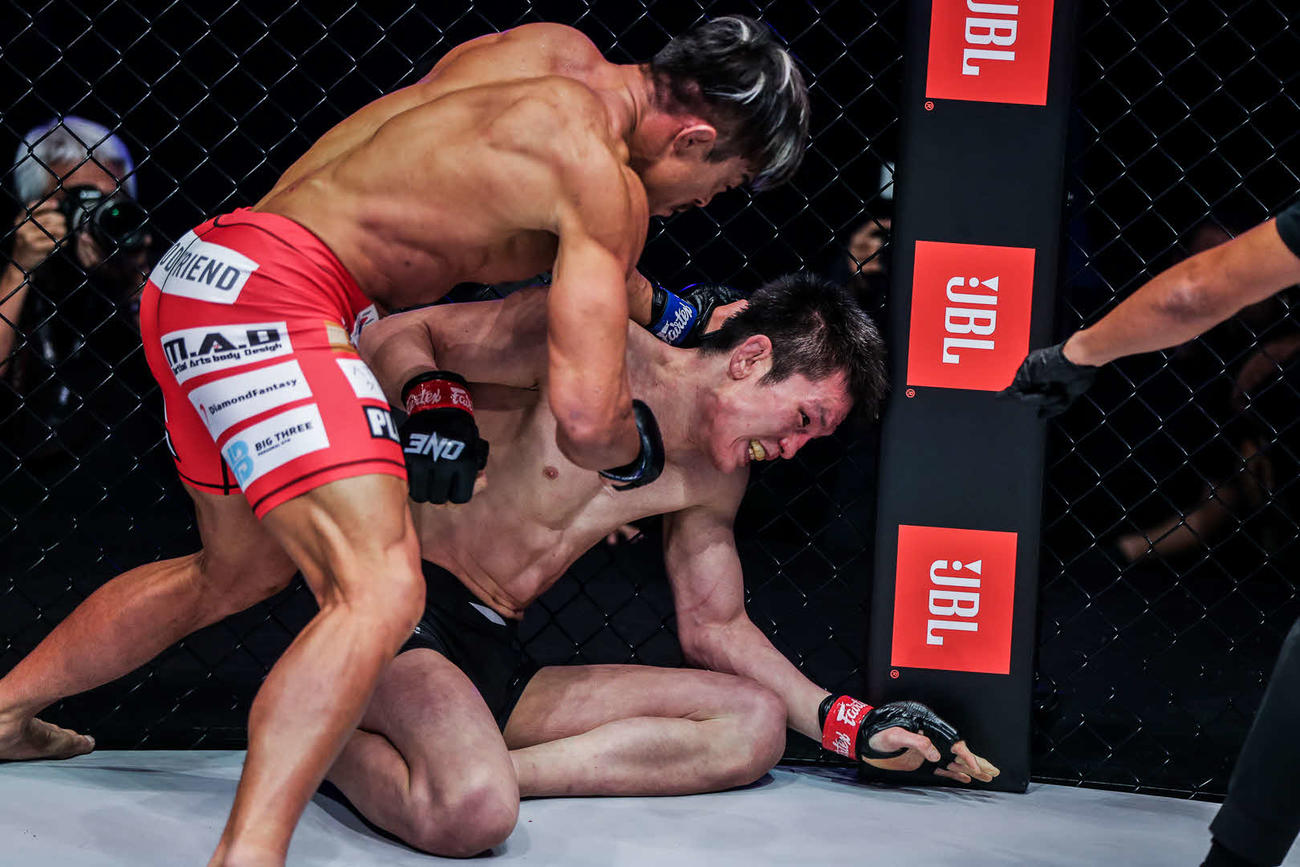 青木真也（右）に打撃の連打を加える秋山(C) ONE Championship