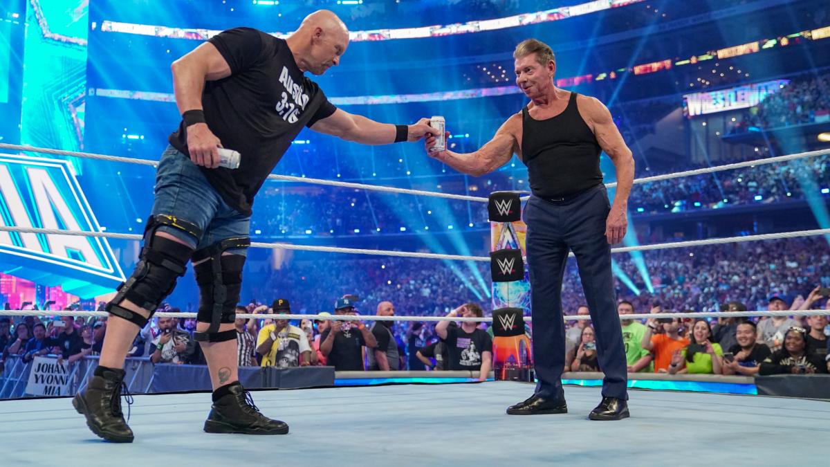 オースチン（左）にビールを手渡され、動揺するマクマホン会長（C）2022 WWE, Inc. All Rights Reserved.