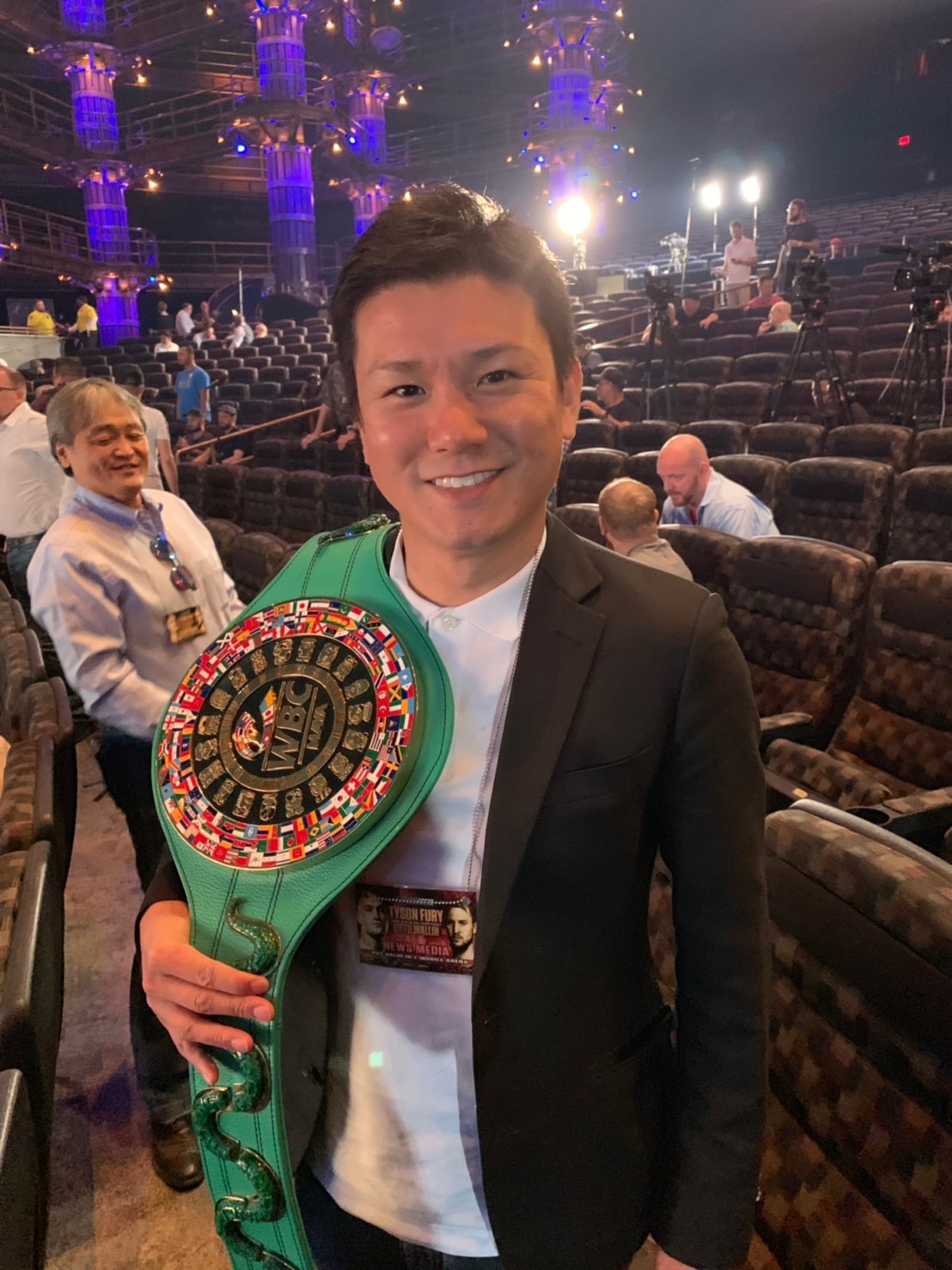 WBCのベルトを肩にかけてポーズを取るWOWOW和佐亨プロデューサー（外部提供）