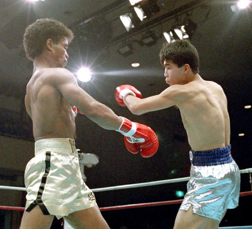 89年1月、日本スーパーバンタム級タイトルマッチでマーク堀越に左フックを繰り出す高橋ナオト（右）