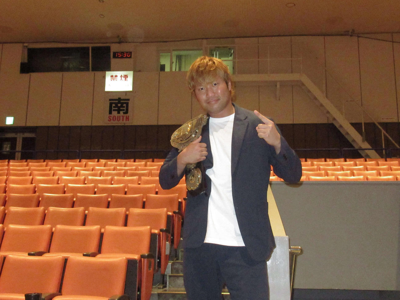 3冠ヘビー級王座ベルトを肩にかけ、ポーズを取る全日本プロレスの宮原（撮影・勝部晃多）