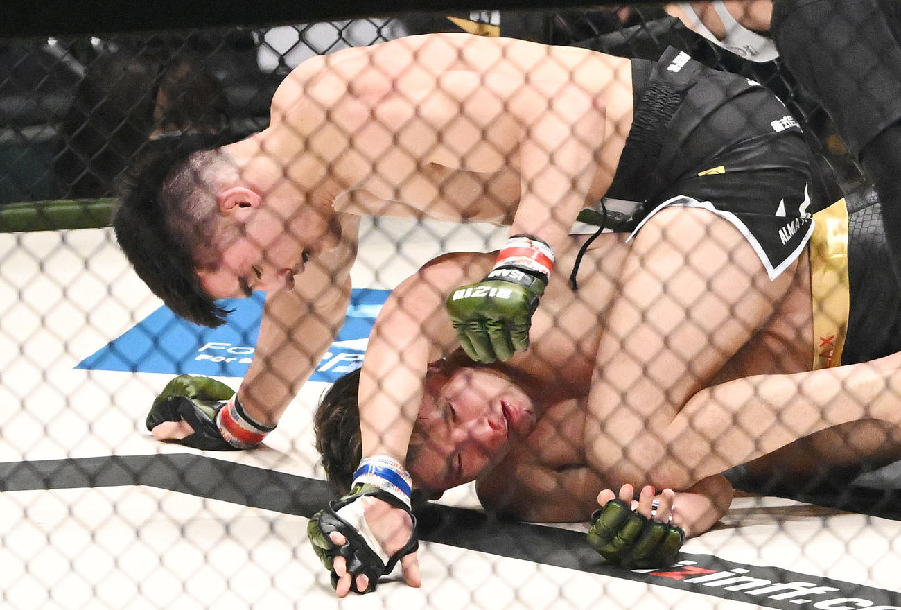 泉武志（下）にパンチを見舞うグラント・ボグダノフ（撮影・滝沢徹郎）
