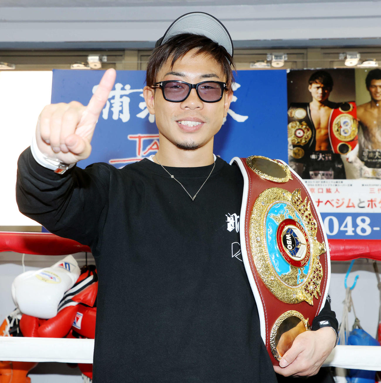 一夜明け、WBO世界ミニマム級チャンピオンベルトを肩に笑顔で写真に納まる谷口（撮影・河田真司）