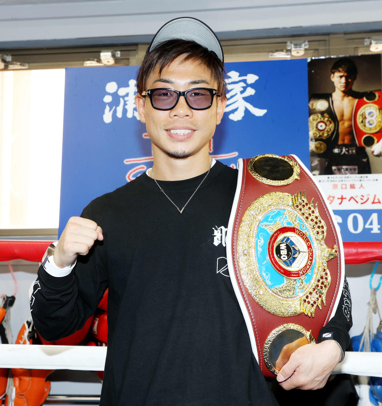 一夜明け、WBO世界ミニマム級チャンピオンベルトを肩にガッツポーズで写真に納まる谷口（撮影・河田真司）